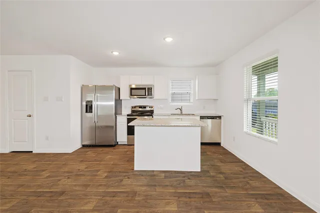 a kitchen with stainless steel appliances a refrigerator sink and microwave