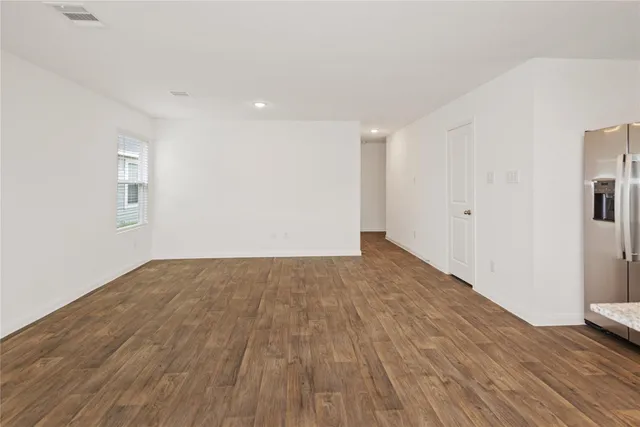a view of empty room with wooden floor