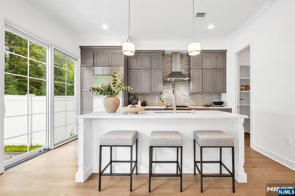 a kitchen with kitchen island granite countertop a table chairs sink and cabinets