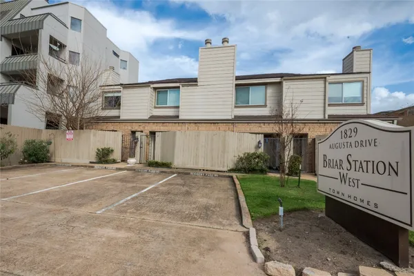 a view of a house with a yard and potted plants