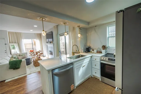 a kitchen with a sink stove and wooden floor