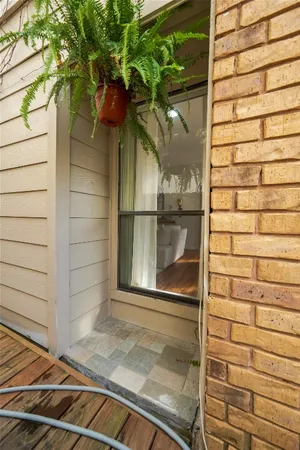 a view of a patio with table and chairs potted plants with wooden floor and fence