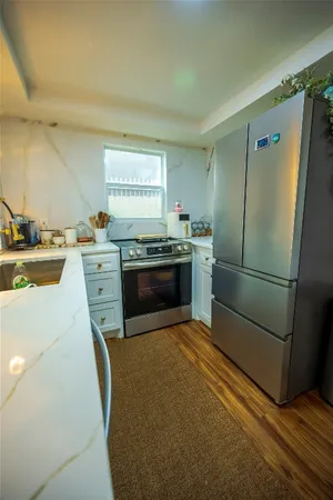 a kitchen with granite countertop a sink stove and refrigerator