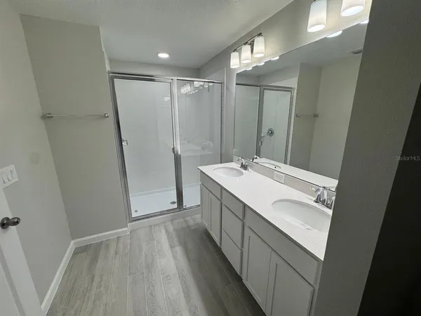 a bathroom with a sink a mirror and a shower