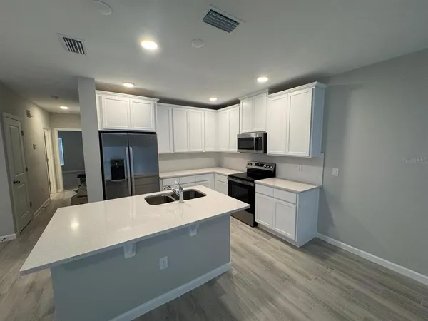 a kitchen with refrigerator and cabinets