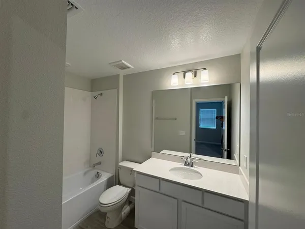 a bathroom with a sink and mirror with toilet