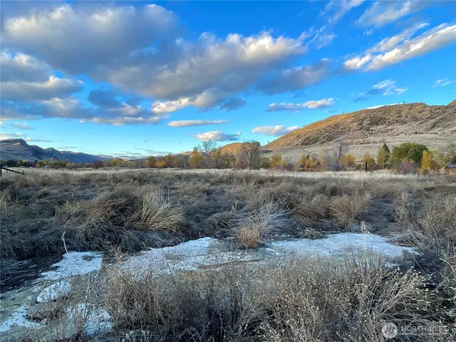a view of a backyard of the house with a table and chairs