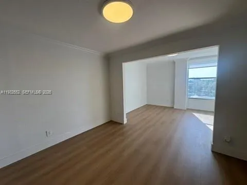 a view of a hallway to a livingroom with furniture and a window