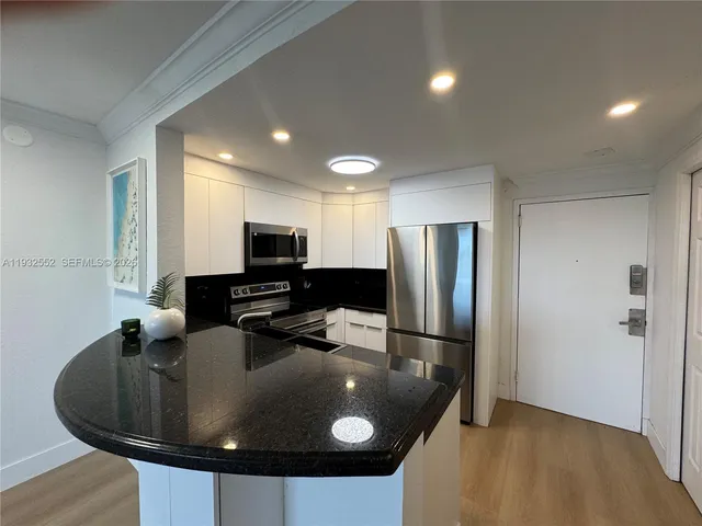 a kitchen with stainless steel appliances a refrigerator a stove a sink and a microwave