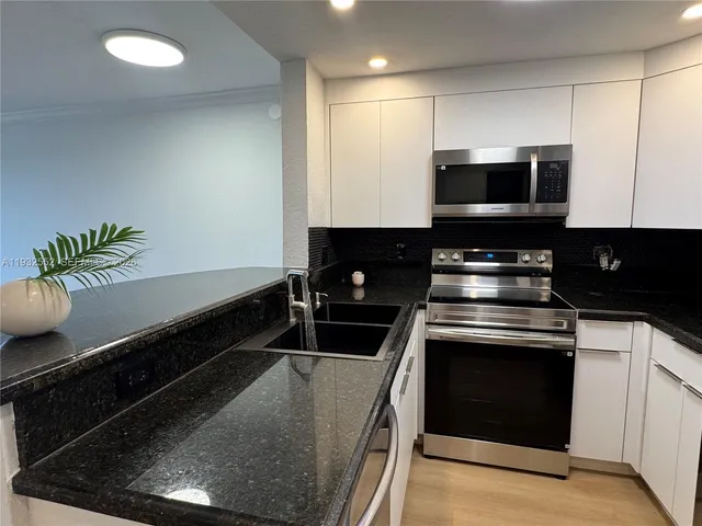 a kitchen with a microwave a stove and cabinets