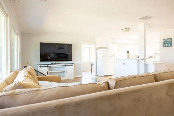 a living room with stainless steel appliances kitchen island granite countertop furniture and a large window