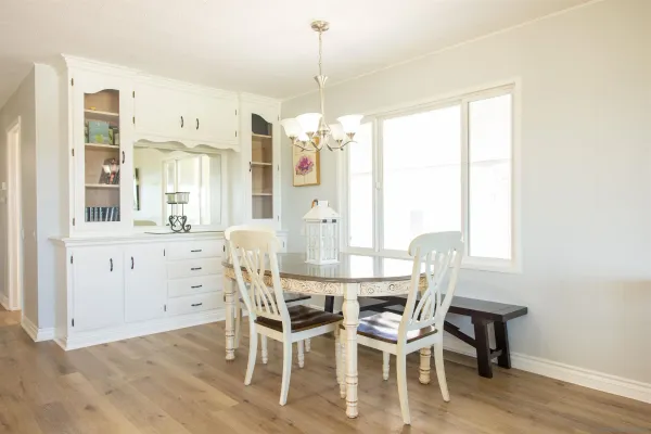 a dining room with furniture a chandelier and wooden floor
