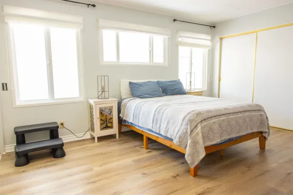 a bedroom with a bed and wooden floor