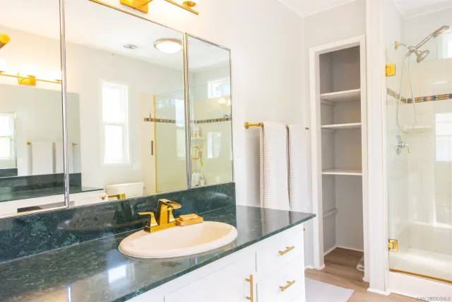 a bathroom with a granite countertop sink and a mirror