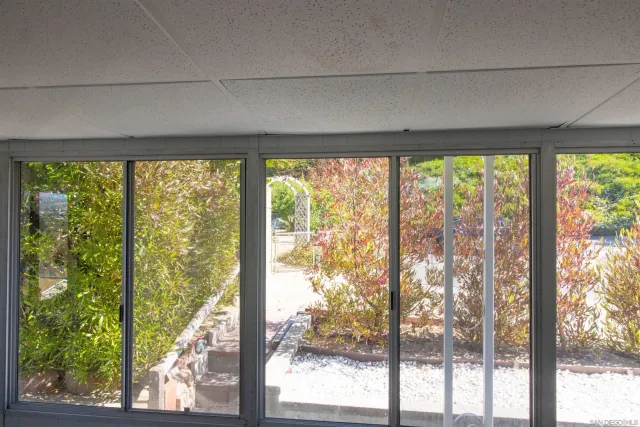 a backyard of a house with large trees and outdoor seating