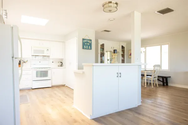 a kitchen with granite countertop white cabinets and white appliances