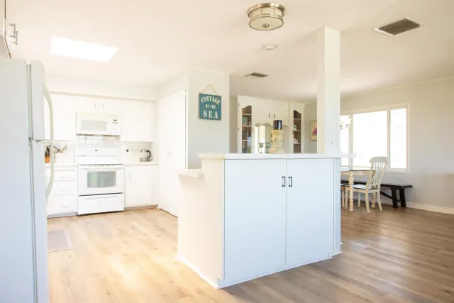 a kitchen with granite countertop white cabinets and white appliances