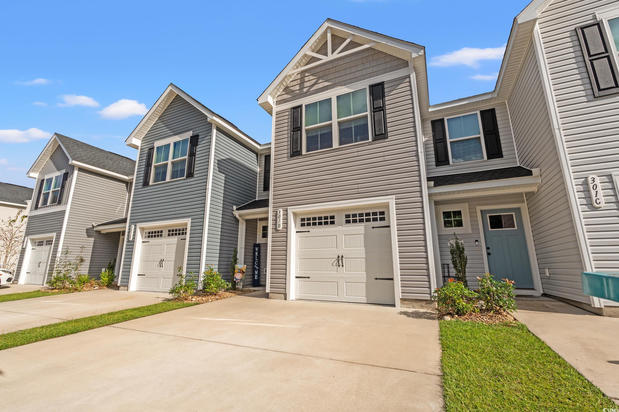 View of front of house with concrete driveway and a garage
