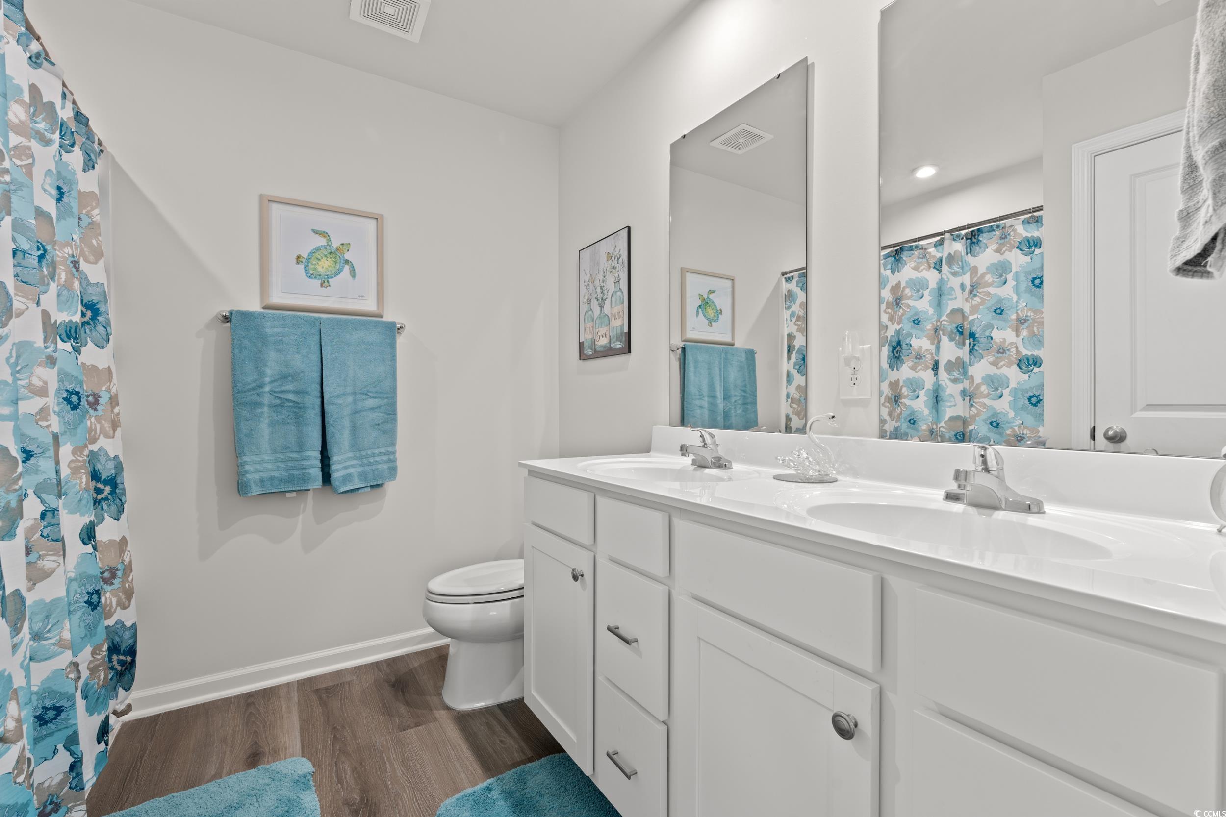 301 Granada Street, Unit D Myrtle Beach, SC 29579 - Photo 14 of 33 Bathroom with double vanity, dark wood-type flooring, curtained shower, and recessed lighting