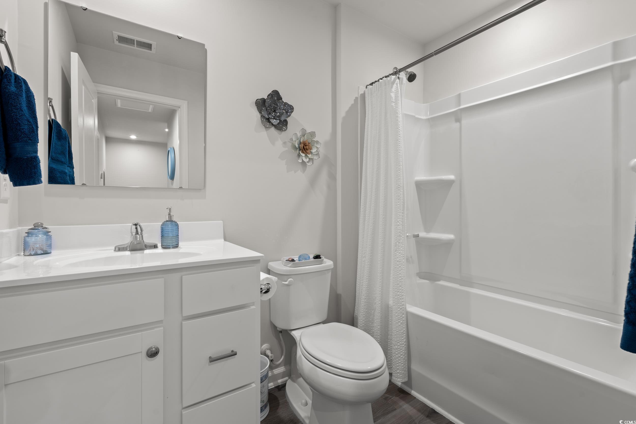 301 Granada Street, Unit D Myrtle Beach, SC 29579 - Photo 18 of 33 Bathroom with shower / bathtub combination with curtain, vanity, and dark wood-style flooring