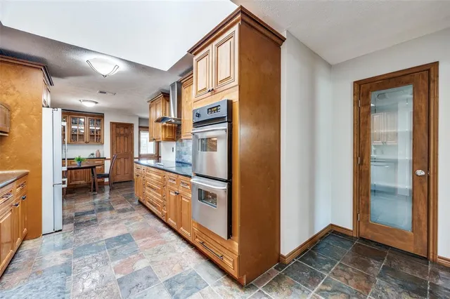 a kitchen with stainless steel appliances granite countertop a refrigerator and a sink