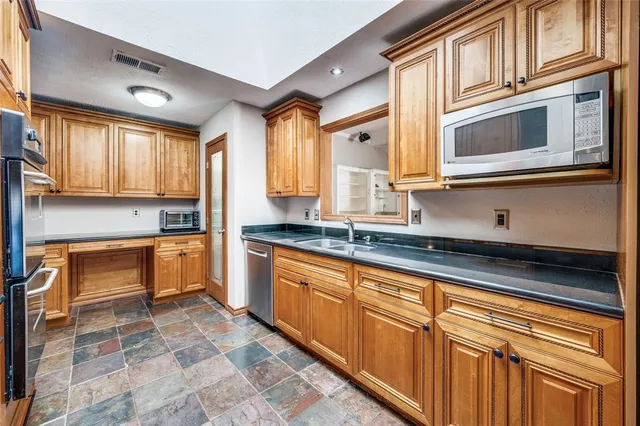 a kitchen with stainless steel appliances granite countertop a sink and cabinets