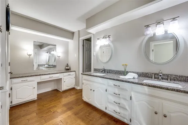 a bathroom with a granite countertop double vanity and a mirror