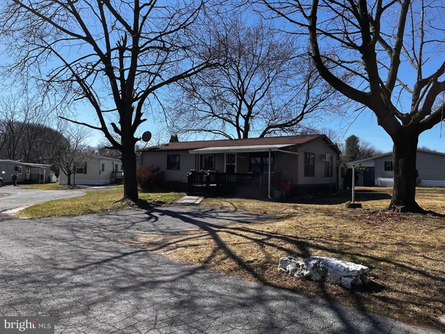 a view of a house with backyard and trees