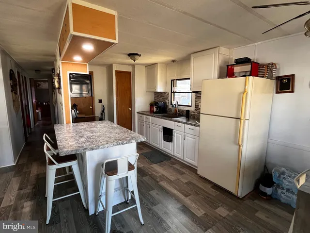 a kitchen with kitchen island wooden floor center island and stainless steel appliances
