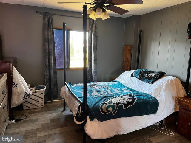 a bedroom with a bed and wooden floor