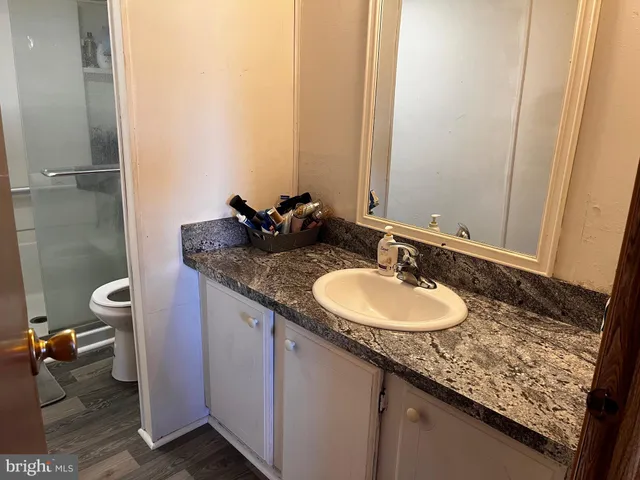 a bathroom with a granite countertop sink and a mirror