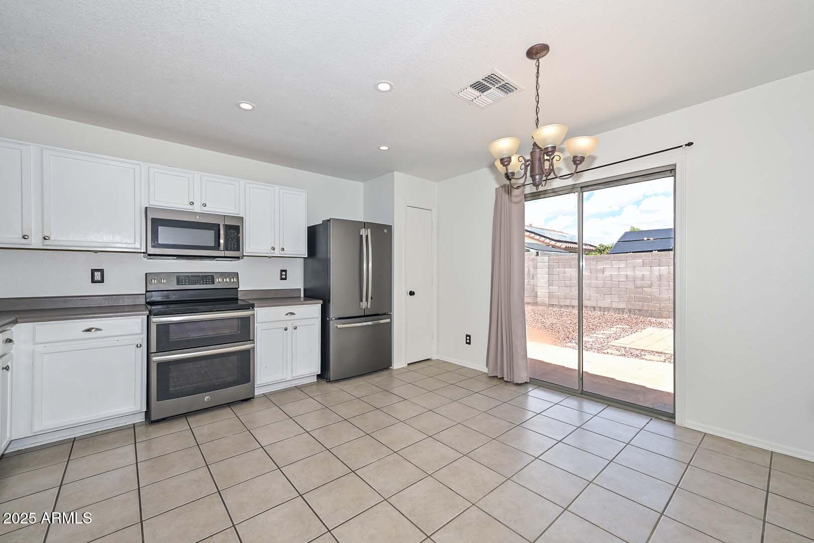 3038 West Roberta Drive Phoenix, AZ 85083 - Photo 11 of 40 a kitchen with stainless steel appliances a refrigerator sink and microwave
