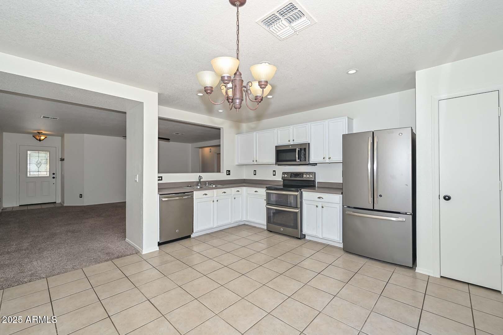3038 West Roberta Drive Phoenix, AZ 85083 - Photo 12 of 40 a kitchen with a refrigerator a stove top oven and kitchen island