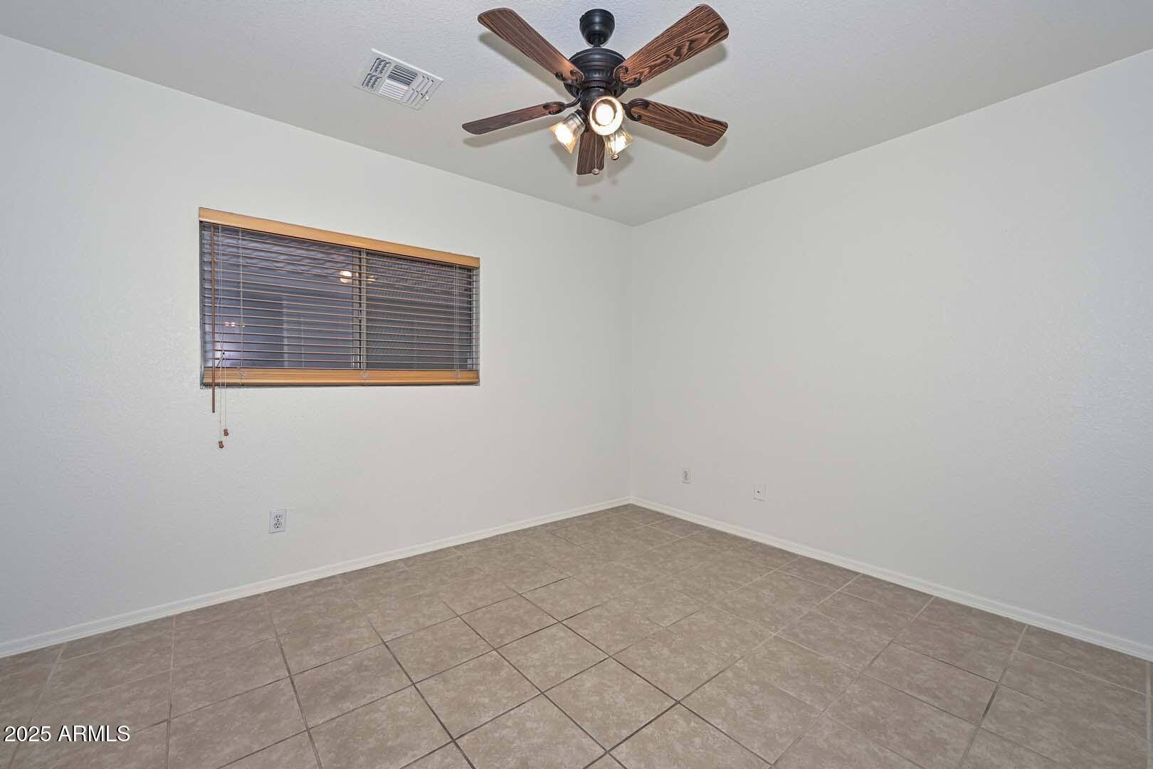 3038 West Roberta Drive Phoenix, AZ 85083 - Photo 16 of 40 an empty room with a window and a fan