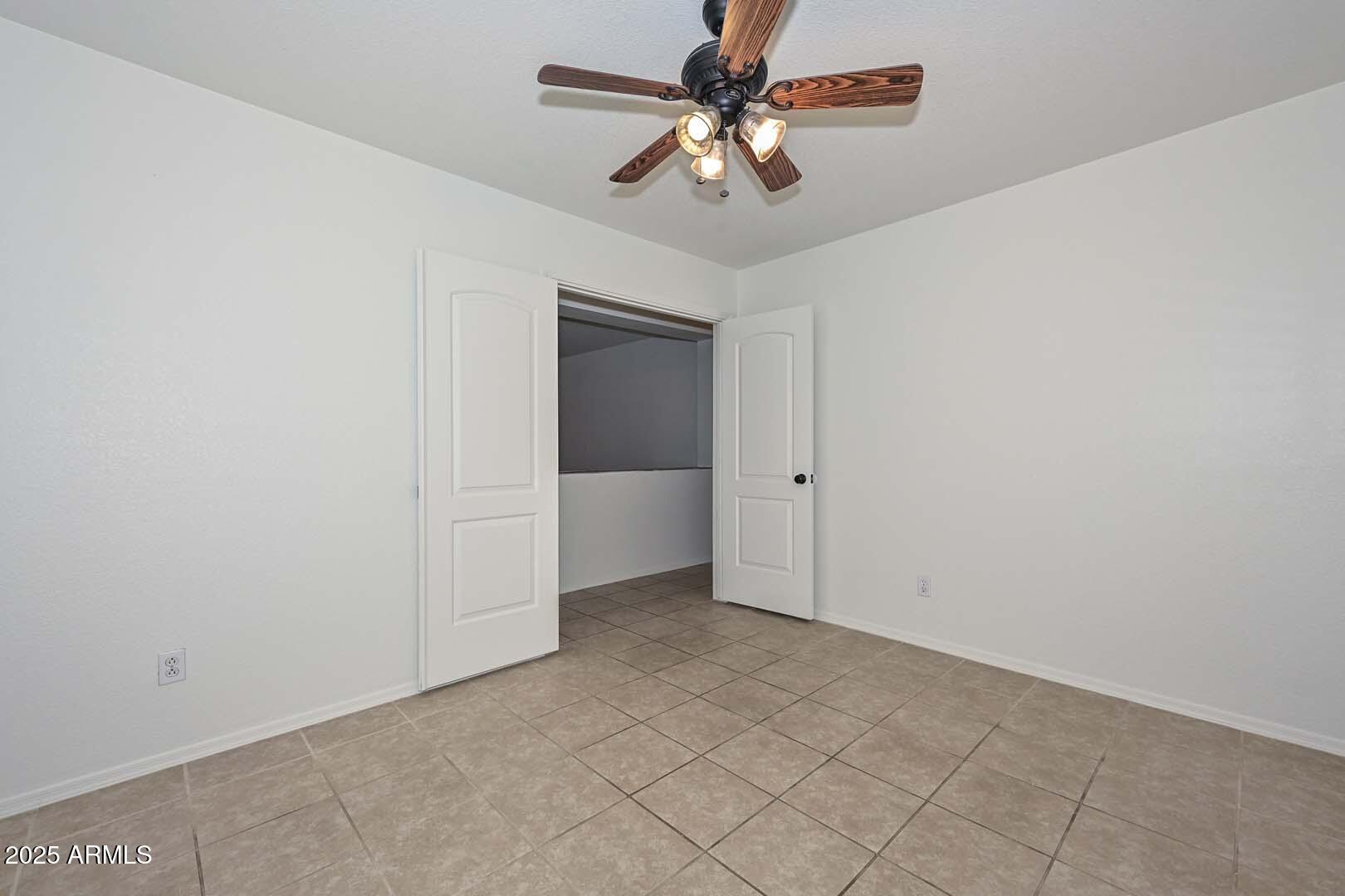 3038 West Roberta Drive Phoenix, AZ 85083 - Photo 17 of 40 an empty room with a ceiling fan and a window