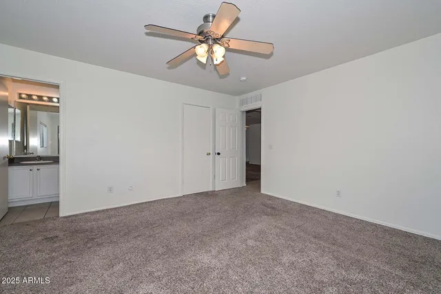 a view of an empty room with a chandelier fan