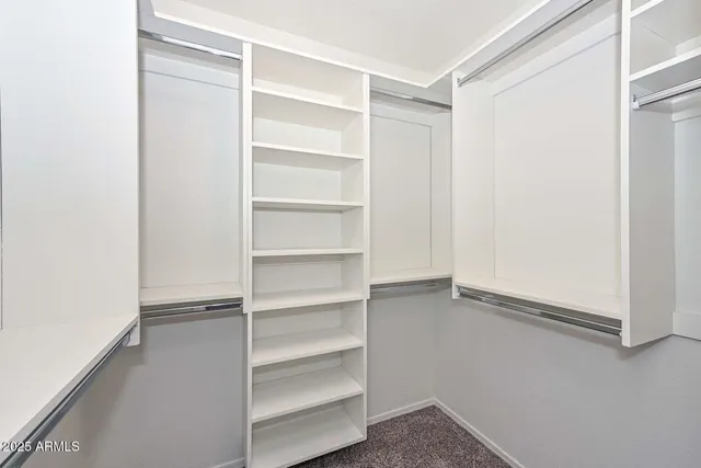 a view of walk in closet with empty racks