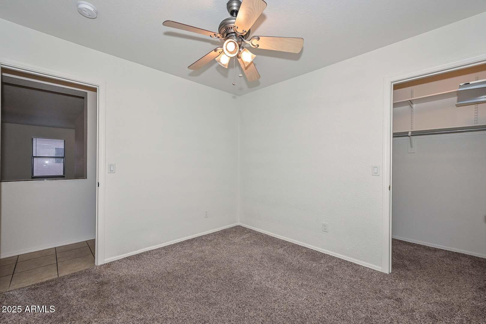 3038 West Roberta Drive Phoenix, AZ 85083 - Photo 24 of 40 an empty room with a chandelier fan and windows