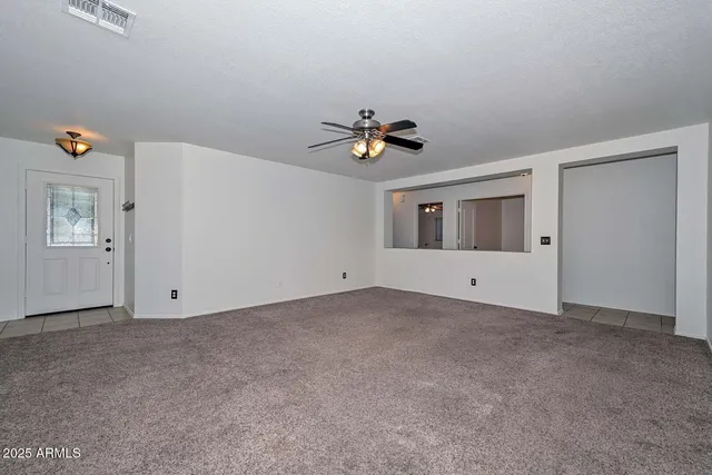 an empty room with closet and windows