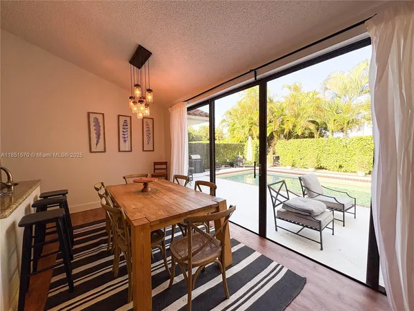 a view of a dining room with furniture large windows and wooden floor