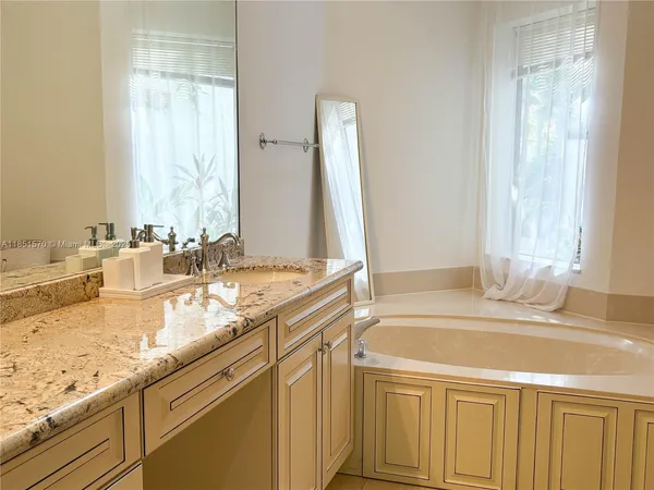 a bathroom with a granite countertop sink and a mirror