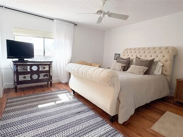 a spacious bedroom with a bed and a flat screen tv