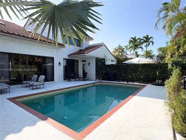 a view of a house with swimming pool and sitting area