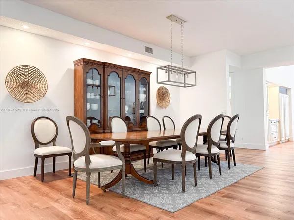 a dining room with furniture a chandelier and wooden floor