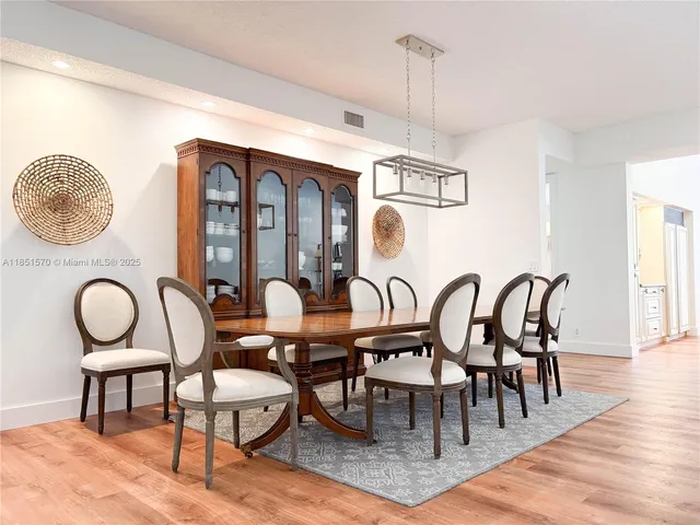 a dining room with furniture a chandelier and wooden floor