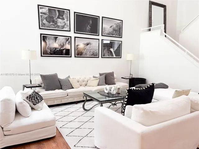 a living room with furniture and a painting on the wall