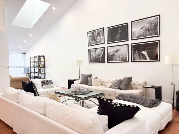 a living room with furniture and painting on the wall