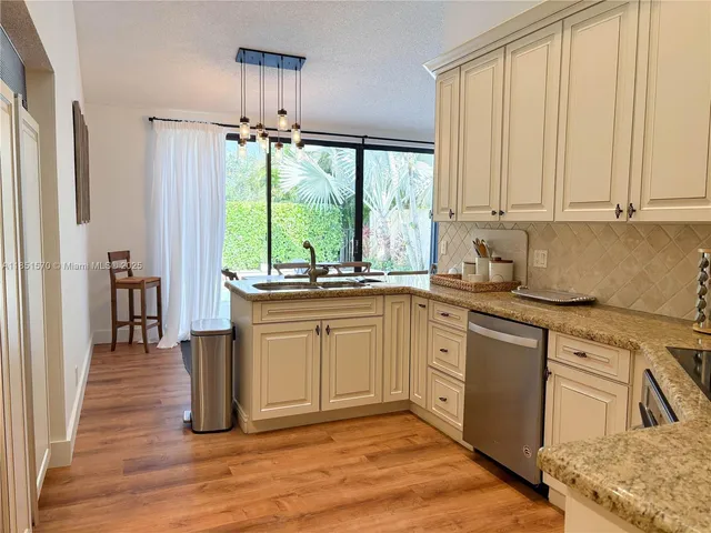 a kitchen with a refrigerator sink and cabinets