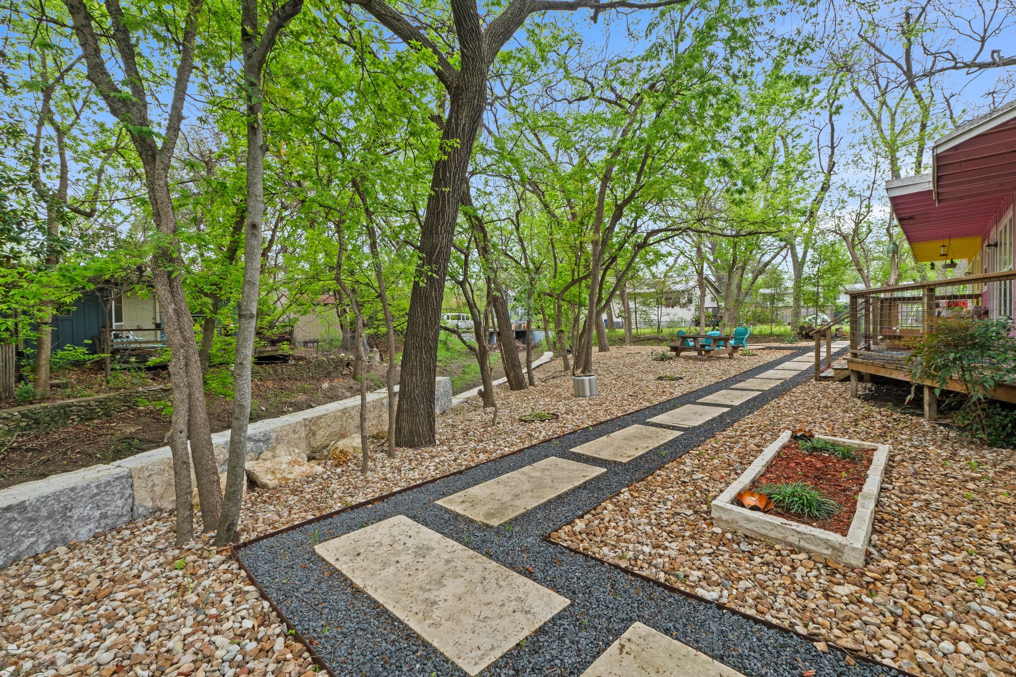 4512 Speedway, Unit A Austin, TX 78751 - Photo 6 of 39 Landscaped backyard featuring a paver pathway set in dark gravel, surrounded by light-colored river rock