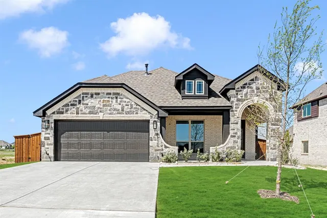 a front view of a house with a garden and yard